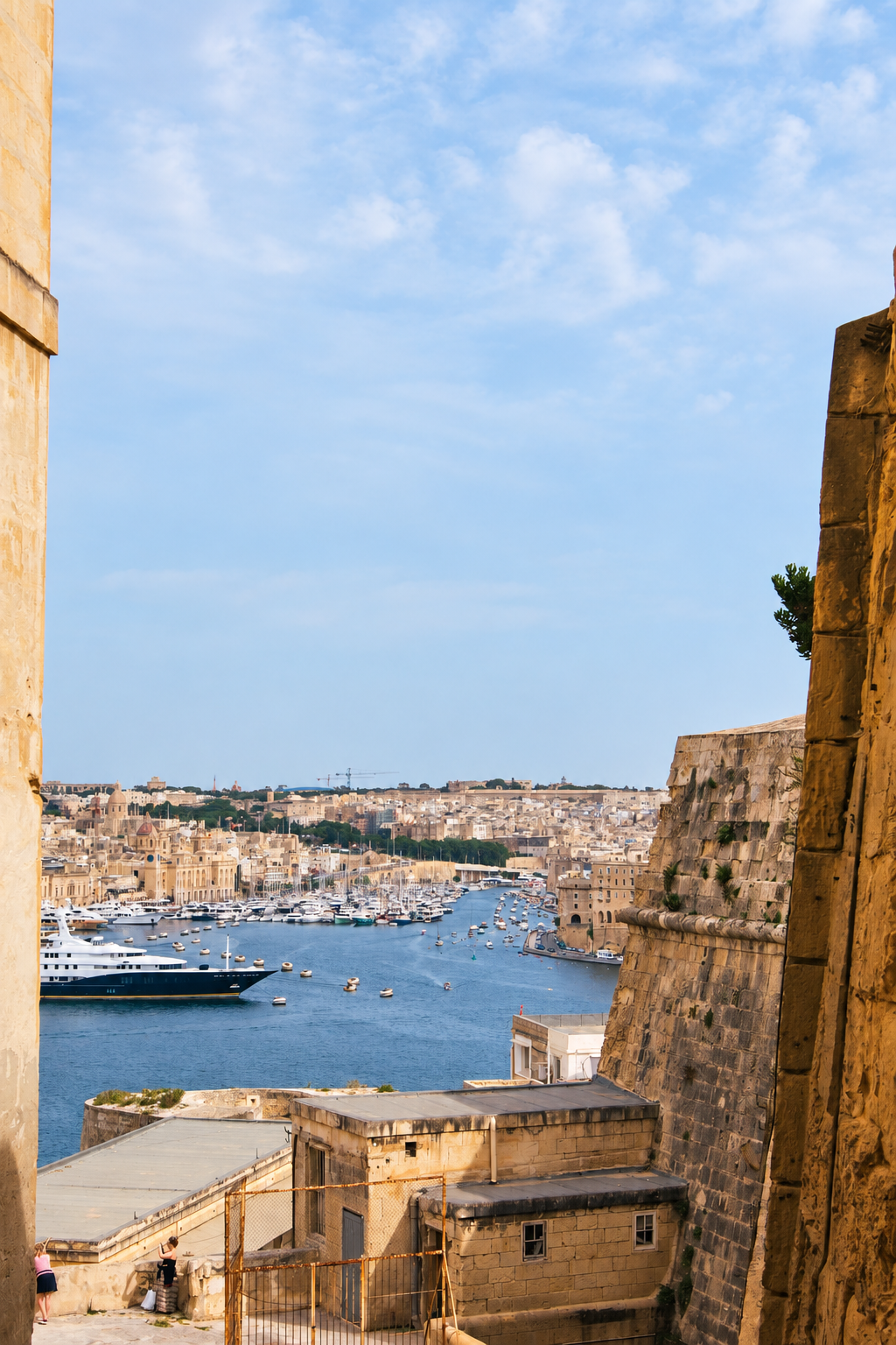 View across a Maltese harbour framed by historic limestone fortifications